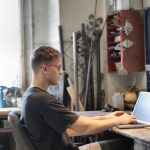 Maintenance Plan - Focused man working on laptop in workshop