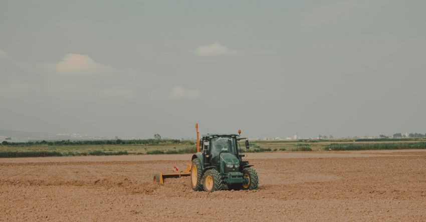 Plows - A tractor is plowing a field in the middle of the desert