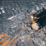 Electric Tractors - Aerial view of excavator working on big coal field of powerplant located in countryside