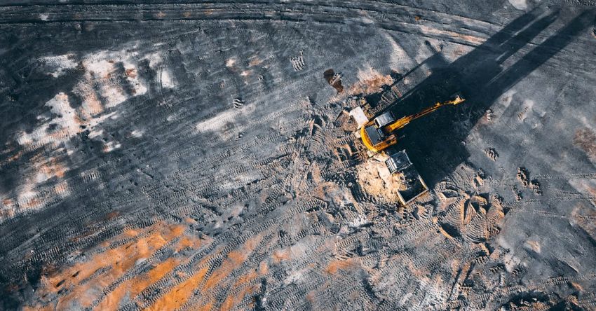 Electric Tractors - Aerial view of excavator working on big coal field of powerplant located in countryside