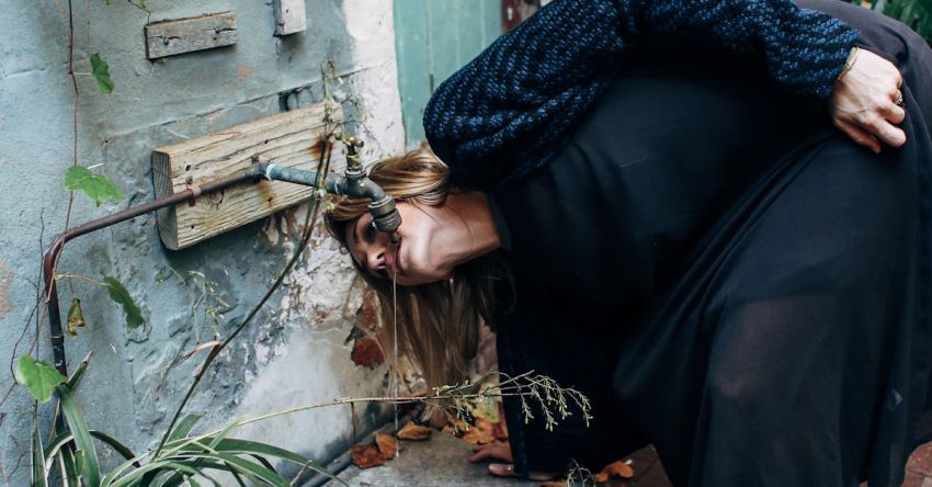 Drip Irrigation - Woman drinking water from a Faucet