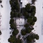 Drone - Areal Photography of Snow Covered Houses Surrounded by Green Trees